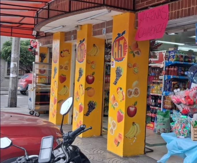 Columnas amarillas con frutas impresas en la entrada de un punto de venta